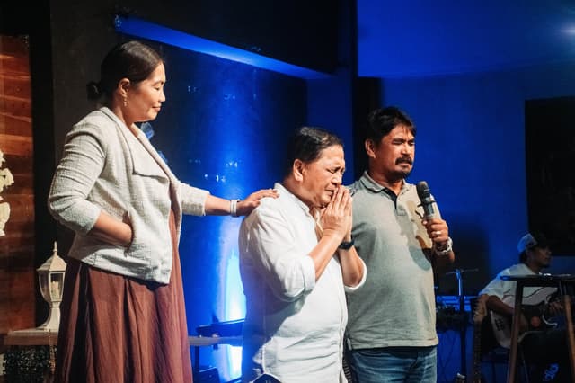 Pastors praying over a church member